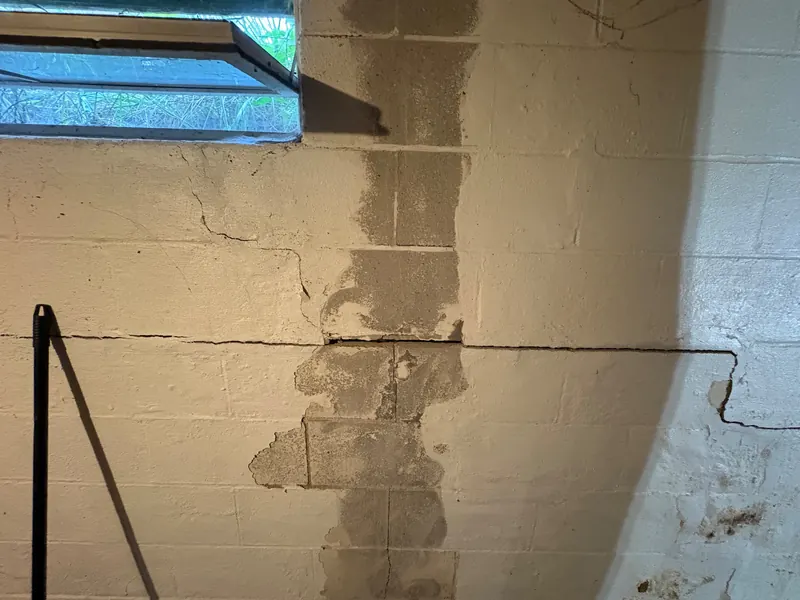 Before: a cracked basement block wall, then the same basement with steel braces installed against the wall
